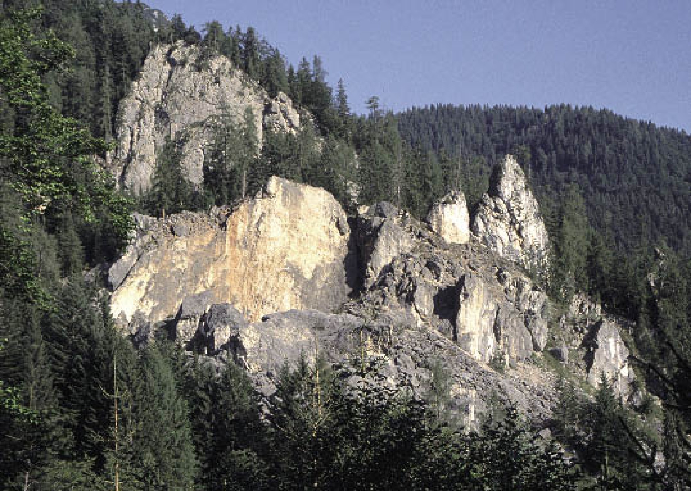 : Blick auf Steinbergkogel: Der vordere Bereich ist besonders stark zerlegt und besteht aus einzelnen Felstürmen und Felswänden. Die Schutthalde mit großen Blöcken zeugt von zahlreichen Felsstürzen in der Vergangenheit. Der letzte größere Abbruch ereignete sich im Dezember 1985. (Bild: D. Ehret)